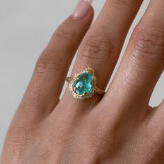 18K Baby Queen Water Drop Paraiba Ring with Full Pavé Diamond Halo | Ready to Ship Yellow Gold 5.5  by Logan Hollowell Jewelry Paraiba Tourmaline Ring Engagement, Exquisite Yellow Gold Emerald Ring With Gemstone, Unique Gemstone Cluster Ring In Yellow Gold, Yellow Gold Diamond Halo Ring With Gemstone, Heirloom Halo Ring In Yellow Gold With Gemstone, Gold Emerald Pear-shaped Ring, Gia Certified Yellow Gold Pear-shaped Jewelry, Gold Pear-shaped Emerald Ring, Heirloom Yellow Gold Halo Ring With Gemstone