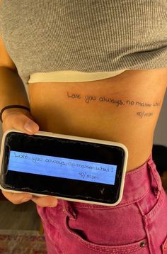 a woman holding a cell phone with writing on her stomach that says love you always, no matter who she is