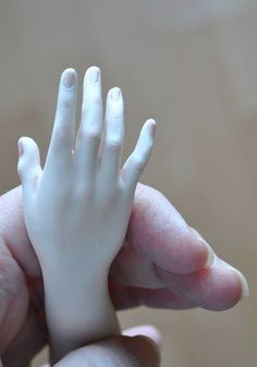 a person holding a fake hand in their left hand, with the fingers extended out