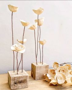 three vases with flowers in them sitting on a table next to a wooden block