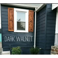 there is a blue house with shutters on the front and side windows that say dark walnut