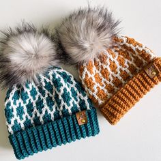 two knit hats with fur pom poms on top of each other, one in orange and the other in teal