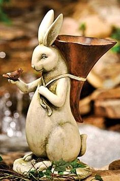 a statue of a rabbit holding a piece of food