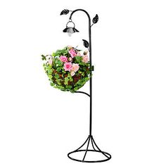 a black metal plant stand with pink and white flowers