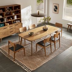 a dining room table and chairs in front of a book shelf with books on it