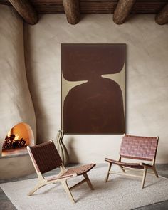 two chairs in front of a fireplace with a painting on the wall behind them and a rug underneath it