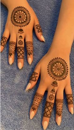 two hands with henna tattoos on them