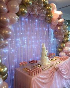 a table topped with a cake and lots of balloons