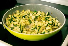 a pan filled with sliced up zucchini on top of a stove burner