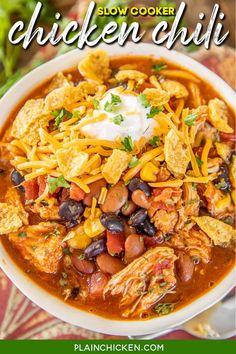 slow cooker chicken chili in a white bowl with tortilla chips and sour cream