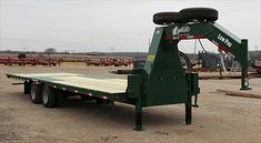 a green flatbed trailer parked in a parking lot