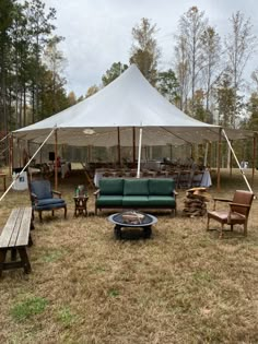 a tent set up with couches, chairs and tables