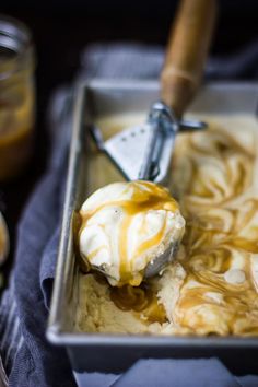 a scoop of ice cream with caramel sauce on it in a metal pan next to other ingredients