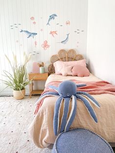 a bedroom with a bed, chair and stuffed animal