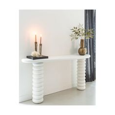 a white table with two candles on it