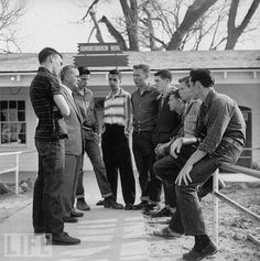 a group of men standing around each other in front of a building