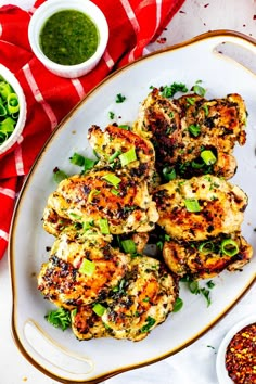 some chicken on a white plate with green sauce