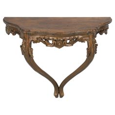 a wooden table with ornate carvings on the top and bottom, against a white background