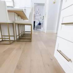 a kitchen with white cabinets and wooden floors