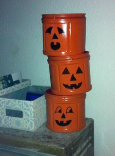 three orange buckets with jack - o'- lantern faces painted on the sides