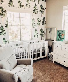 a baby's room with white furniture and wallpaper