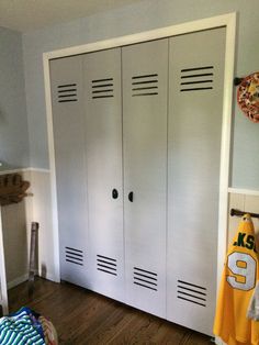 a bedroom with two white lockers and a yellow jersey hanging on the closet doors