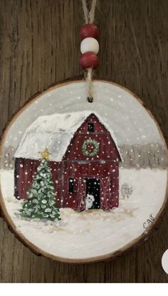 a christmas ornament with a barn and tree