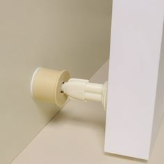 a close up of a white wall with a cup attached to the side of it