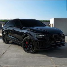 a black suv parked in front of a building