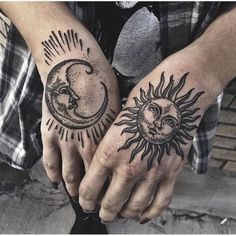 two hands with sun and moon tattoos on their palms, one holding the other's hand