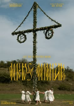 a group of people standing around a large cross made out of flowers and branches with the words miss & mister written on it