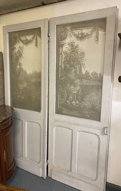 two doors with pictures on them in a room