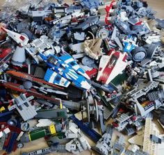 a pile of assorted legos sitting on top of a wooden floor next to each other