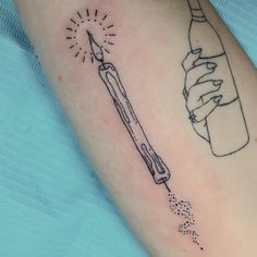 a person with a tattoo on their arm has a bottle and a pencil in it