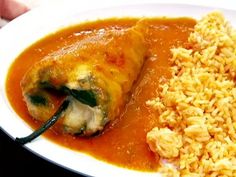 a white plate topped with rice and enchiladas