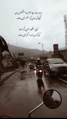 a man riding a motorcycle down a rain soaked street