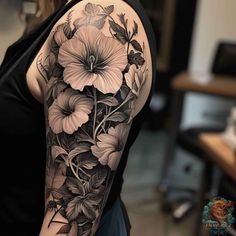 a woman's arm with flowers and leaves on it