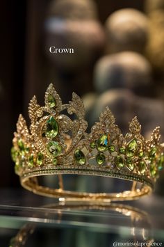 a tiara is shown on display in a glass case with the words crown above it