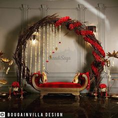 a red couch sitting in front of a white wall next to a wreath with flowers on it