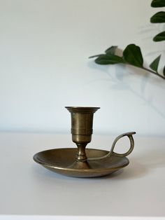 a small brass candle holder on a white table