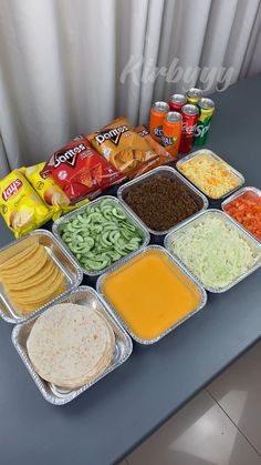 a table topped with trays of food and containers filled with different types of foods