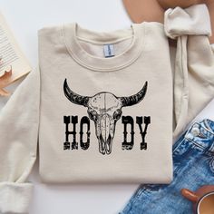 Country western Howdy Sweatshirt featuring a cozy medium-heavy fabric blend of 50% cotton and 50% polyester. Perfect for colder months, this sweatshirt gives off a laid-back vibe with its classic fit and crew neckline. It is relevant for western-themed events, casual wear, and gift-giving occasions. Product features - Knit in one piece without side seams for reduced fabric waste - Ribbed knit collar with seam for elasticity and shape retention - Double-needle stitching for durability - Tear-away Cowboy Sweater, Country Music Outfit, Sweatshirt Western, Fabric Waste, Themed Events, Country Western, Ranch Style, Western Cowboy, Country Music