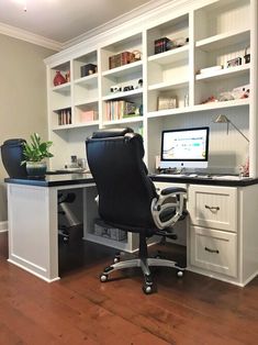 an office desk with a computer on top of it in front of bookshelves