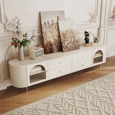 there is a white shelf with pictures on it in the corner next to a rug