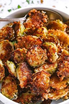 a bowl filled with cooked brussel sprouts and topped with parmesan cheese