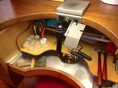 a wooden desk with tools and other items on it's side, including a coffee maker