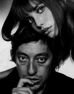 a man and woman are posing for a black and white photo with their hair blowing in the wind