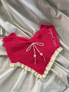 a red crocheted blanket with white trim on it and the words love is written in cursive writing