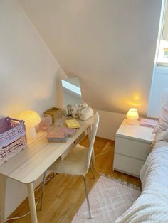 a bedroom with a bed, desk and mirror in it's corner next to a window