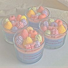 four glass bowls filled with different types of candies